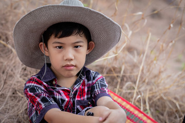 Cute portrait asian little boy sitting on grass