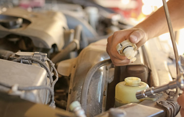 Auto mechanic repairing car in service center, closeup
