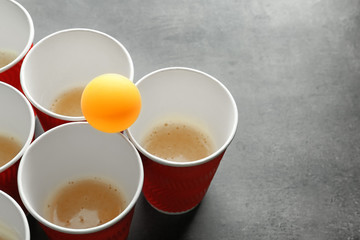 Cups and ball for beer pong on table