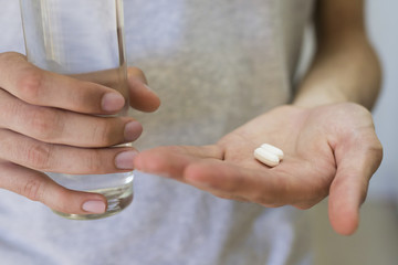 hands with pills or medicine and a glass of water