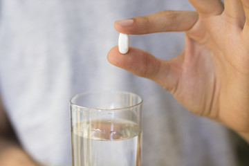 hands with pills or medicine and a glass of water