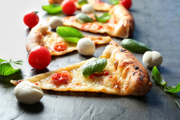 Slices of delicious pizza on grey background