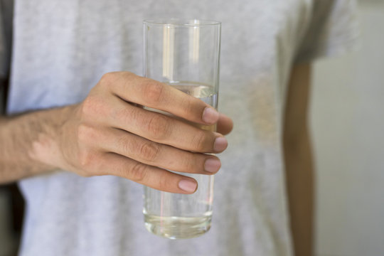 hands with a glass of water