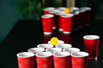 Obraz premium Cups and plastic ball for beer pong game on table