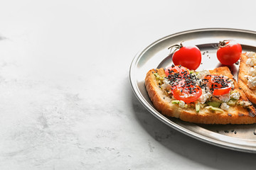 Plate with tasty toast on light background