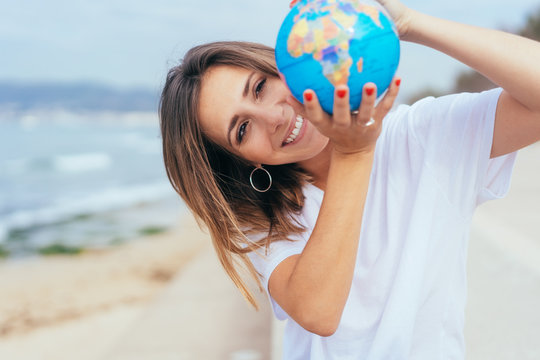 Happy excited woman holding up a world globe