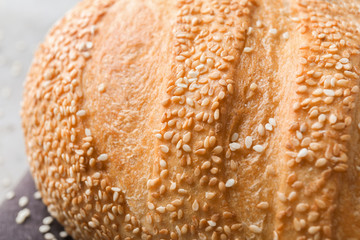 Fresh tasty bread with sesame seeds on table, closeup