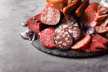 Assortment of delicious sausages on slate plate
