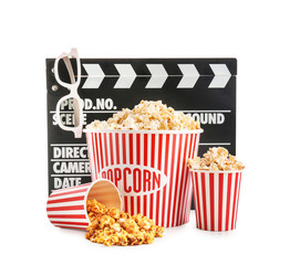 Cups with tasty popcorn, glasses and clapperboard on white background