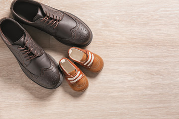 Big and small shoes on light background. Father's day