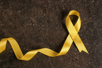 Yellow ribbon on dark background. Cancer concept