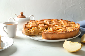 Plate with delicious apple pie on table