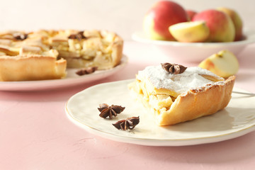 Plate with piece of delicious apple pie on light table