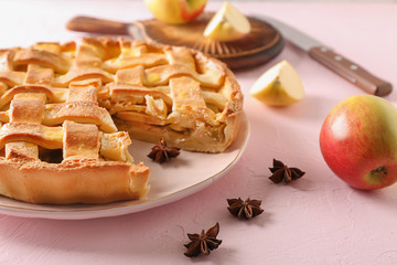 Fototapeta premium Plate with delicious apple pie on light background