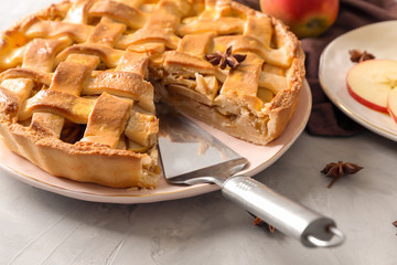 Plate with delicious apple pie on grey background, closeup