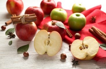 Fresh ripe apples and cinnamon on light wooden background
