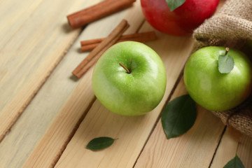 Fresh ripe apples and cinnamon on wooden background