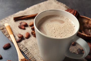 Cup of delicious hot cocoa on grey background, closeup