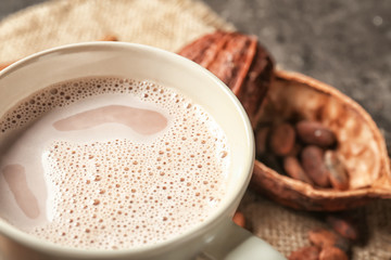 Cup of delicious hot cocoa on grey background, closeup