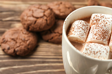 Cup of delicious hot cocoa with marshmallows on table, closeup