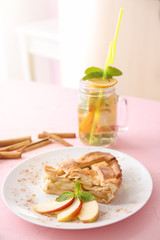 Plate with piece of delicious apple pie on table