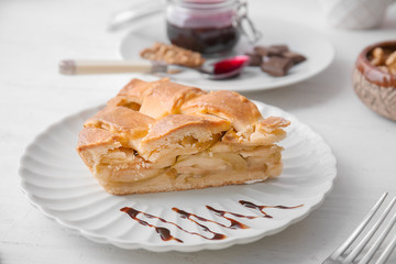 Plate with piece of delicious apple pie on wooden table