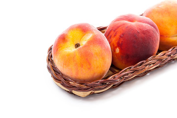 Group of ripe peach fruit in basket isolated on white background.