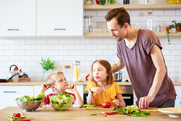 Photo of man with daughter cooking vegetables