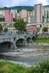 Genoa, Italy - June, 12, 2018:  residential district of Genoa on an embankment of river, Italy