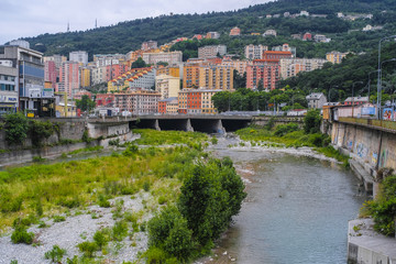 Genoa, Italy - June, 12, 2018:  residential district of Genoa on an embankment of river, Italy