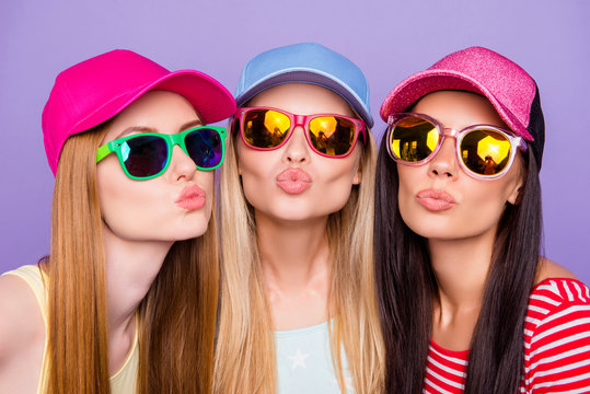 Head shot portrait of lovely sweet trio, blonde brunette ginger sending kiss with pout lips at camera isolated on vivid violet background