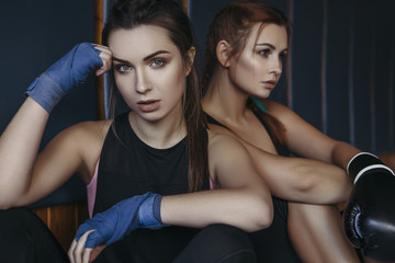 Fototapeta na wymiar Fit slim young beautiful brunette women boxing in sportswear. Dark dim light. Toned image