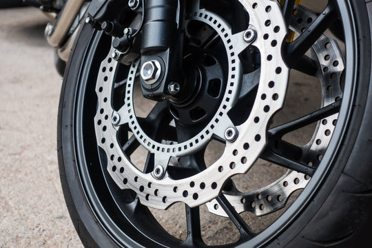 Fototapeta Closeup detail of racing motorcycle disk brake with ABS system and tire on road