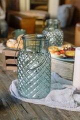 Sweet bar of delicious cakes, candies and pies on a wooden table, decorated with fabric and glass vases. Cute cozy home dinner for a family and friends. Soft window light