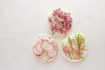 Fototapeta na wymiar Healthy snack concept Rice bread Crispy bred Radish slices Sprouts Marrow slices Cottage cheese High key Top view Copy space 