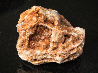 Wulfenite crystals on rough rock on black