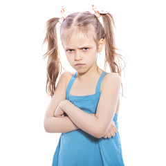 Young seven years old brunette girl in blue dress on a white isolated background. Angry, unhappy, sad emotions on her face