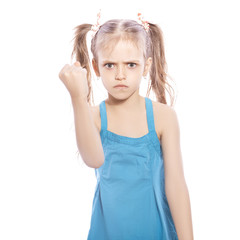 Fototapeta premium Young seven years old brunette girl in blue dress on a white isolated background. Angry, unhappy, sad emotions on her face