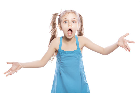 Young seven years old brunette girl in blue dress on a white isolated background. Amazement, surprise emotions on her face