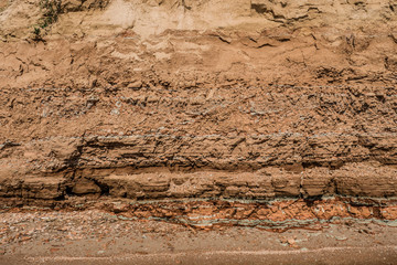 Fototapeta na wymiar Rocky clay texture on a cliff near the sea