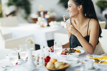 Attractive woman eating in restaurant