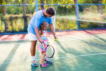 Poster Family playing tennis on outdoor court © famveldman
