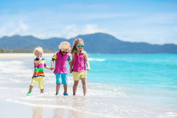 Kids on tropical beach. Children playing at sea.