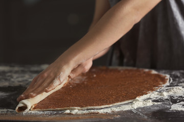 Woman making cinnamon rolls in kitchen