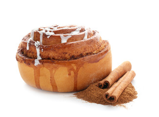 Tasty sweet bun with cinnamon sticks and powder on white background