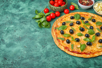 Tasty pizza with olives and ingredients on color background