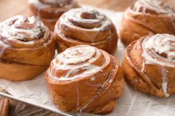 Tasty cinnamon buns on cooling rack, closeup