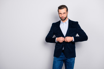 Portrait of handsome serious thoughtful minded graceful modern dreamy elite groomed classy well-dressed classy masculine man fastening velvet dark blue jacket isolated on gray background copy-space