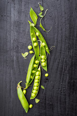 Opened pods of peas on black