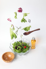 Mix leafy vegetable salad green purple lettuce glass bowl elevated flying dropping